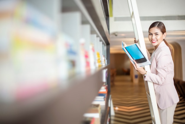 Beautiful woman is reading books in library 