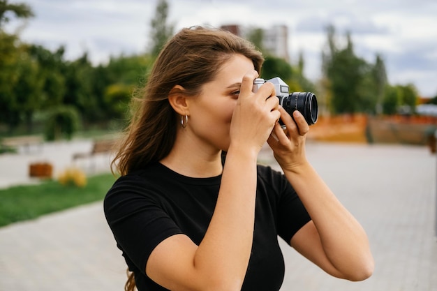 Beautiful woman is taking a picture with her vintage camera on a windy day