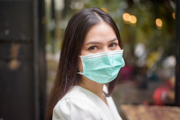 Beautiful woman is wearing face mask in coffee shop