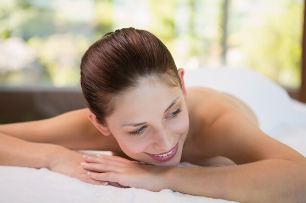 Beautiful woman lying on massage table at spa center