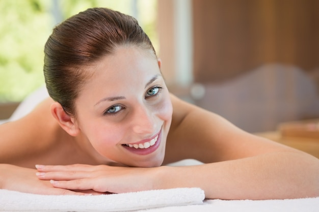 Beautiful woman lying on massage table at spa center