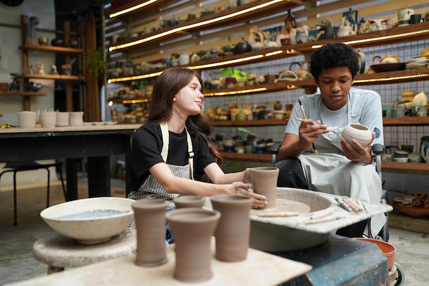 Beautiful woman making ceramic pottery on wheel hands closeup woman in freelance business hobby