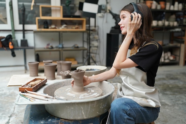 Photo beautiful woman making ceramic pottery on wheel hands closeup woman in freelance business hobby