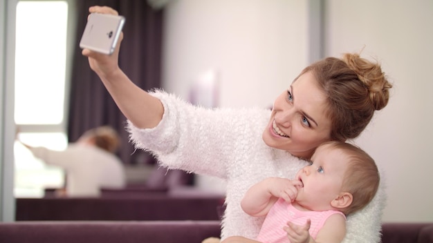 Photo beautiful woman making selfie with baby mother with child taking mobile photo