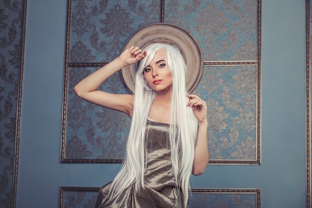 Beautiful woman model with long platinum white hair in the wall of the interior