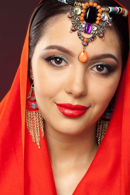 Beautiful woman in oriental style with mehendi on dark 