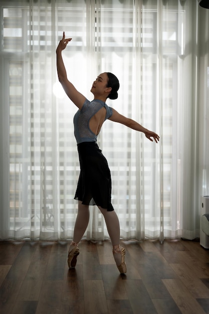 Beautiful woman performing a ballet dance practicing her dance move at home ballet concept