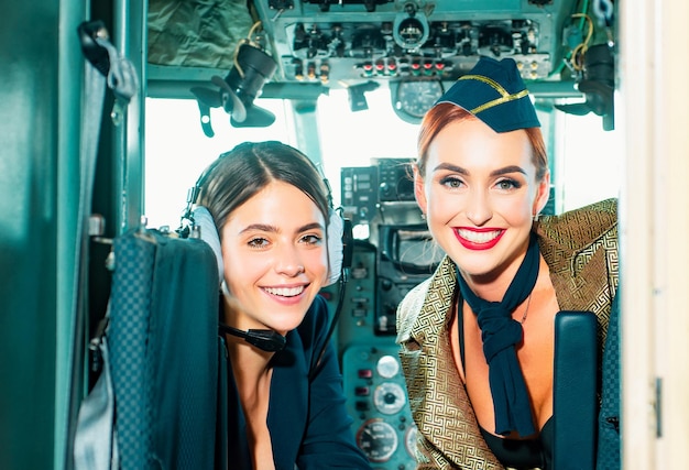 Beautiful woman pilot wearing uniform happy and successful flight looking at camera in plane girls l