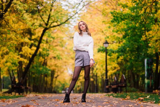 Beautiful woman playing ukulele guitar at outdoor in autumn forest