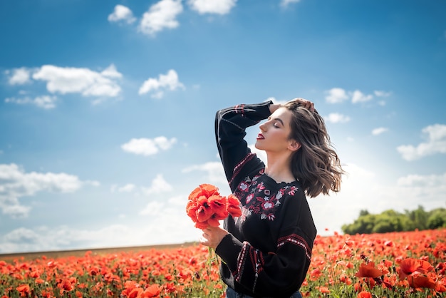 Beautiful woman in a poppy field, enjoy summer time. Romantic mood nature lover