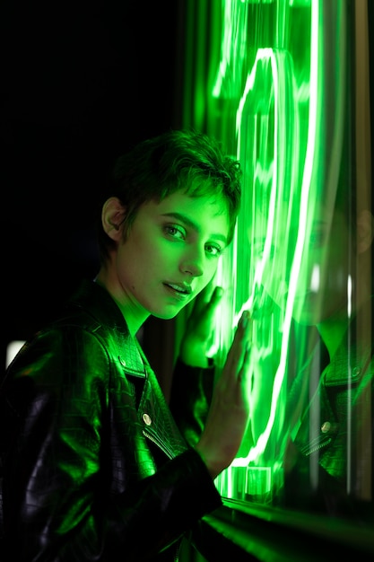 Beautiful woman posing at night time in green neon light