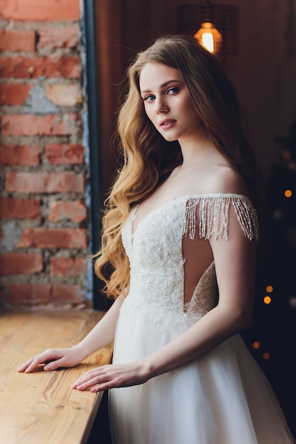 The beautiful woman posing in a wedding dress.