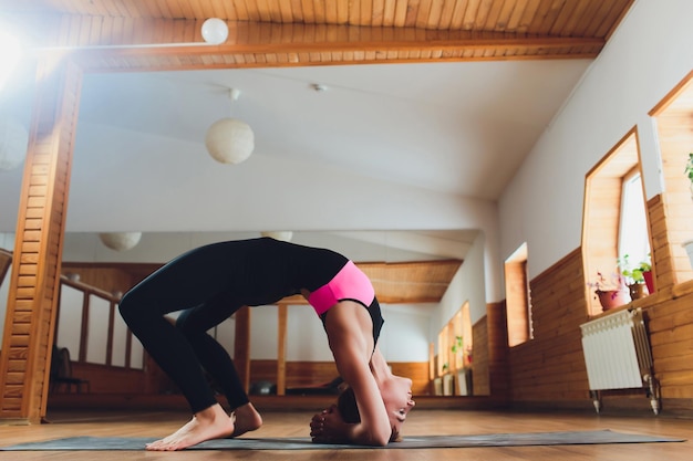 Photo beautiful woman practices backbend yoga asana urdhva dhanurasana upward facing bow pose at the yoga