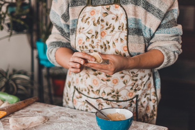 Beautiful woman prepares dumplings in her home kitchen dumplings with potatoes