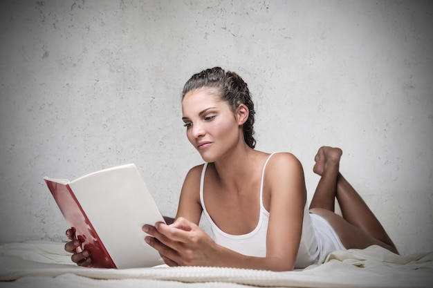 Beautiful woman reading in bed