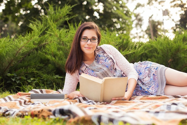 Beautiful woman reading a book in the park