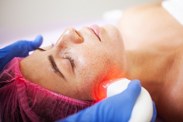 Beautiful woman receiving vacuum facial massage in beauty studio