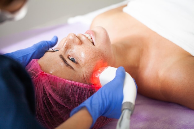 Photo beautiful woman receiving vacuum facial massage in beauty studio