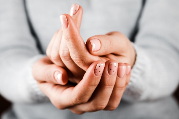 Beautiful woman's hands with pink nails on the white background. Nail varnishing in pink color. Manicure, pedicure beauty salon concept.