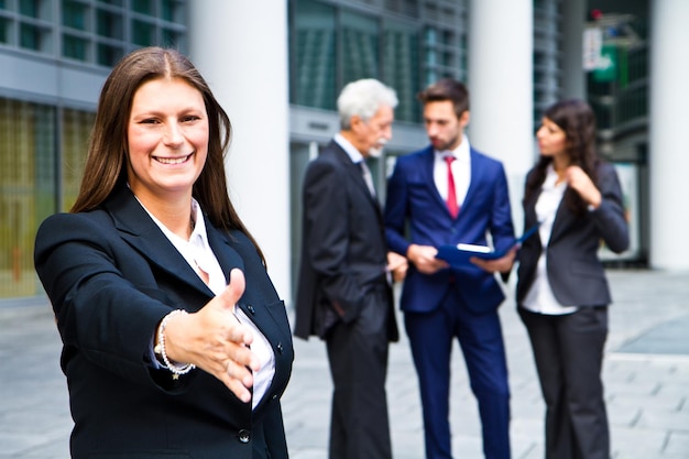 Beautiful woman shaking hand with  the background of business people