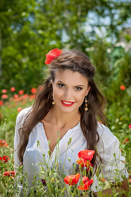 Beautiful woman sitting in the poppy flower