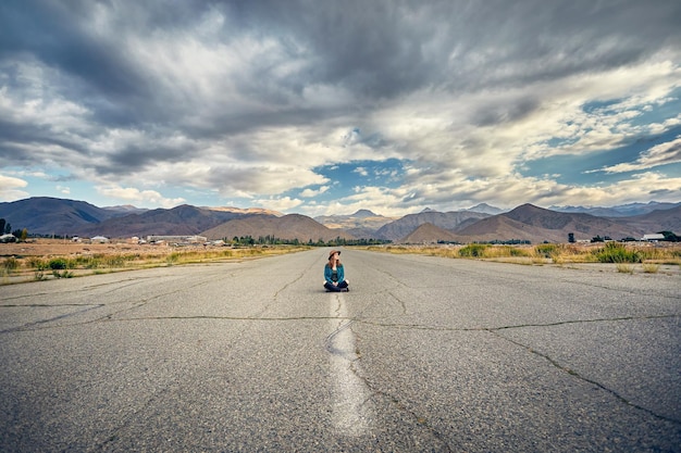 Beautiful woman sitting on the road