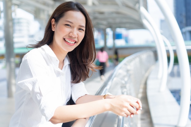 Beautiful woman smiling with happiness feeling standing outside office