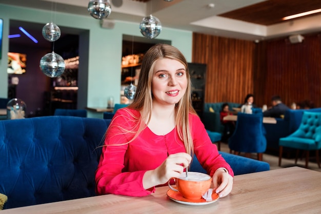 Beautiful woman spending leisure time in the cafe drinking coffee having coffee break