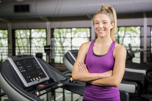 Beautiful woman standing on treadmill at gym