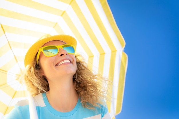 Beautiful woman on summer vacation Low angle view portrait of happy person against blue sky background