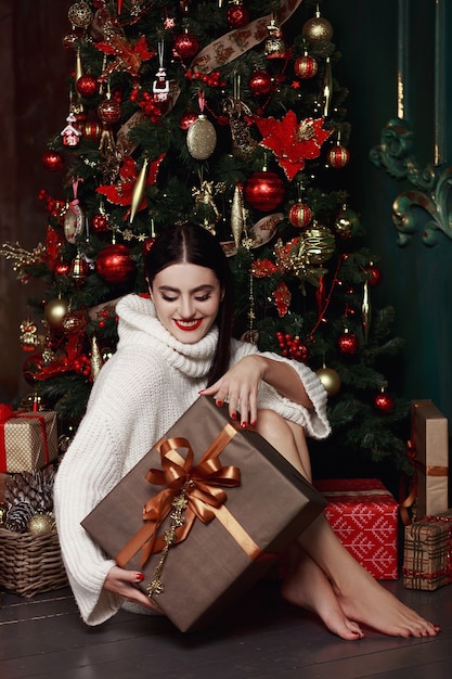 Beautiful woman in sweater holding gifts