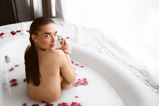 Beautiful Woman Taking Milk Bath And Looking At Camera