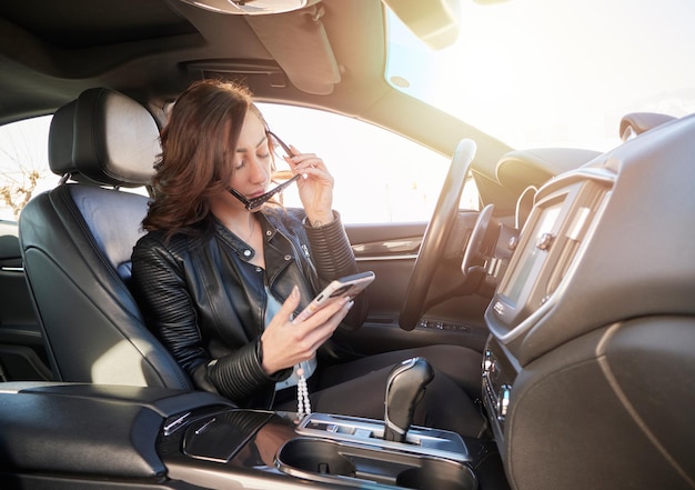 Beautiful woman talking to mobile inside a car