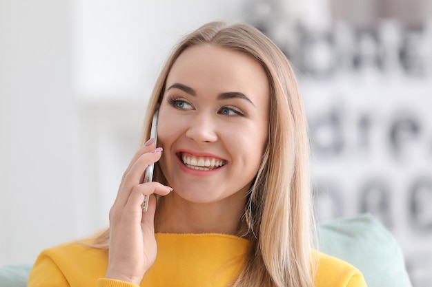 Beautiful woman talking on mobile phone indoors