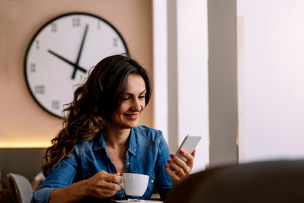 Beautiful woman using her mobile in coffee shop.