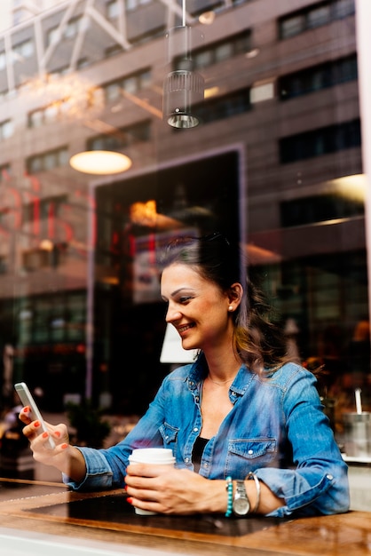 Beautiful woman using her mobile in coffee shop.