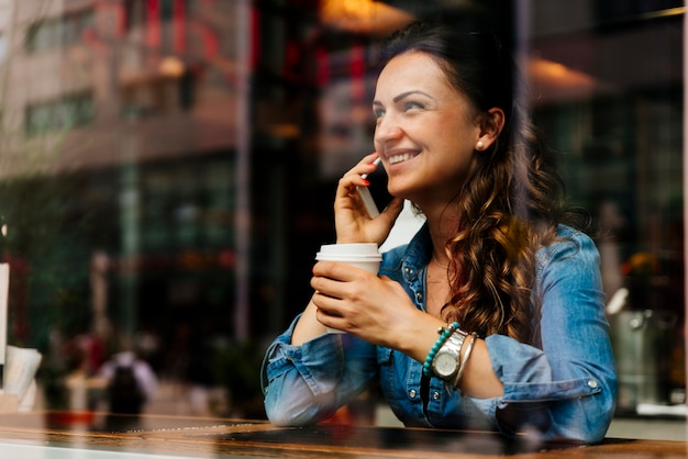 Beautiful woman using her mobile in coffee shop.