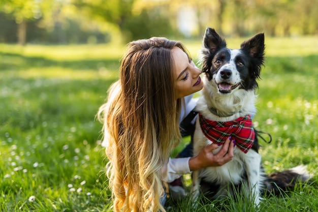 Beautiful woman walking, playing with cute dog outdoors in nature