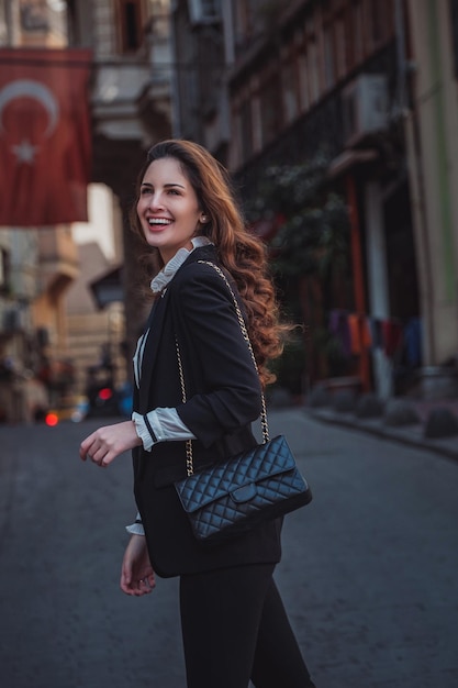 Beautiful woman walks at Istiklal streeta popular location in Beyoglu districtIstanbulTurkey walking on Istanbul street and enjoy arabic city architecture