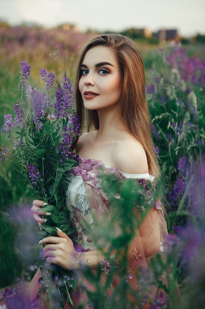 Beautiful woman wearing elegant dress posing with flowers