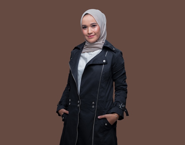 Beautiful woman wearing hijab posing on plain background