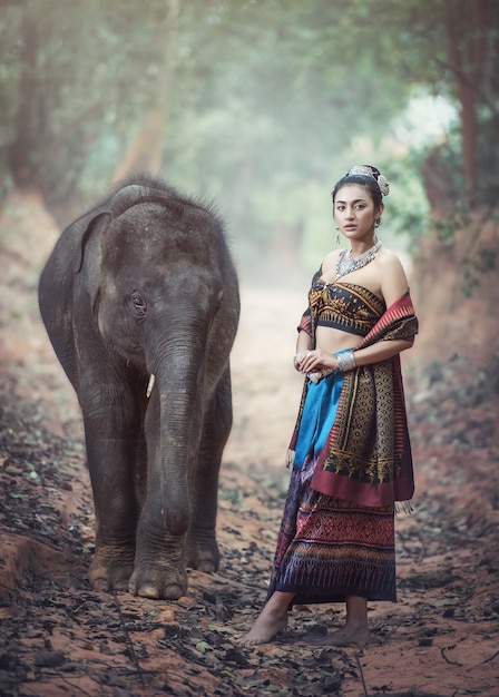 Beautiful woman wearing Thai silk traditional dresses with elephant, Surin Province, Thailand