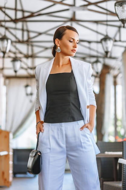 Beautiful woman in a white business suit in a restaurant