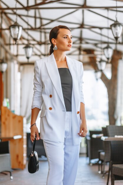 Beautiful woman in a white business suit in a restaurant