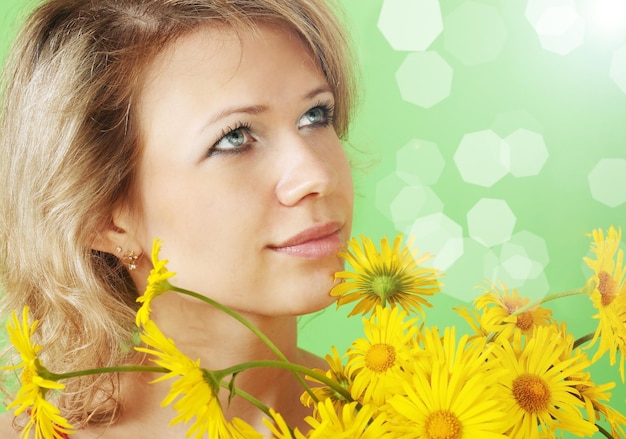 A beautiful woman with a bouquet of yellow daisies