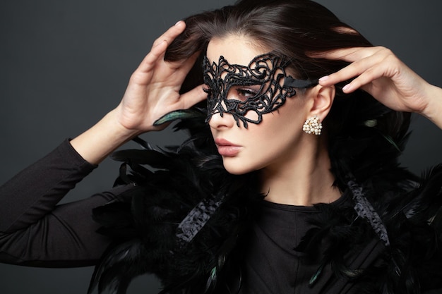 Photo beautiful woman with the carnival mask on black holiday fashion model portrait beauty hairstyle