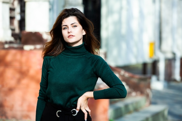 Beautiful woman with clean skin poses on the street in the city