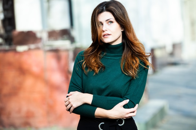 Beautiful woman with clean skin poses on the street in the city