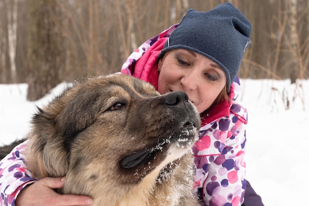 Beautiful woman with a dog in winter Sheepdog Fluffy big guard dog Dog walking