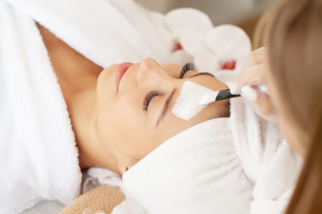 Beautiful woman with facial mask at beauty salon.